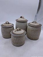 Full set of four speckled stoneware canisters with lids