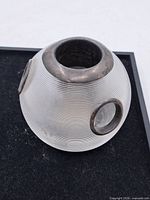 Side view of ribbed frosted glass sphere with silver collar and mount