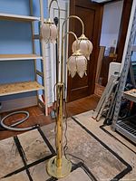 Full view of brass-tone floor lamp with three glass flower shades