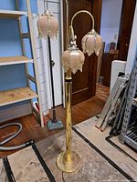Full view of floor lamp showing brass column, base, three arms and shades