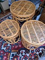 All three rattan nesting tables grouped on rug, top view