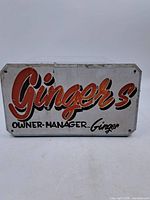 Front of painted sign showing "Ginger's" graphic