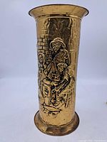 Front view showing embossed musicians on brass vase