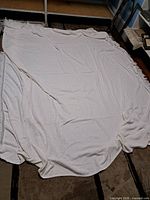 Full view of square white chenille bedspread spread out on floor