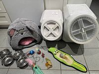 Overview of all items: cat bed, two storage bins, feeders, toys