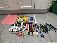 Overall view of entire stationery lot laid out on floor
