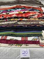 Stacked assortment of folded cotton fabrics showing variety of prints and colours