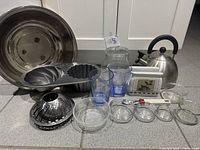 Group shot showing all items including Bundt pan, steamer basket, kettle, bowls, tumblers, jar, napkin holder, peeler
