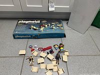 Boxed Playmobil set with loose extra figures and accessories laid out