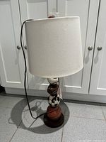 Lamp assembled with shade, stacked sports balls visible