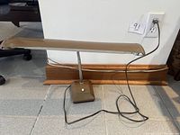 Full view of brown metal desk lamp unplugged