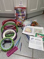 Overview of weaving kit box, looms, needles, yarn, needlepoint supplies