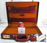 Open attaché case showing interior, handle, lock, tag, and scale reference