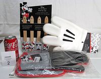 Set showing packaged spatulas, white silicone oven mitt, sealed pot holder, coke can for scale