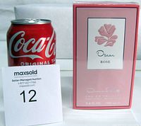Front view of sealed Oscar de la Renta Rose Eau de Toilette box beside soda can for scale and lot card