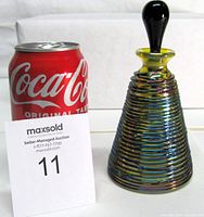 Full view of perfume bottle beside soda can for scale and auction card