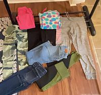All eight garments laid out – leggings, jeans, pajama pants