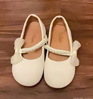 Top view of both shoes showing pearl strap and bows