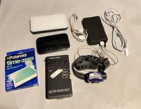 Entire lot showing radio, headlamp, three power banks, two cables and Polaroid film