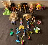 Group shot of all dolls, keychains, detached mermaid tail