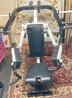 Front view of chest press machine showing frame, seat, backrest and arm pads