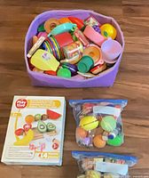 Overall lot with purple bin full of play food, boxed Playtive set and two sealed bags