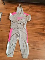Full view of hoodie and sweatpants laid flat on floor