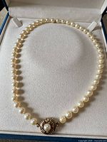 Full view of pearl necklace in presentation box showing strand and clasp