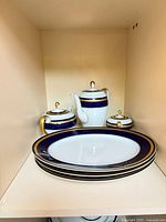Stack of three large platters with teapot, coffee pot and sugar pot