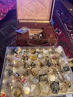 Open leather jewelry box with tray of assorted accessories