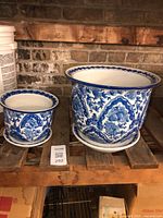 Large and small blue and white ceramic planters on shelf
