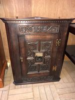 Full view of front of carved wood corner cabinet
