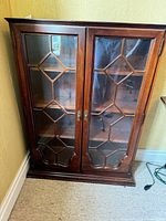 Front view of wooden display cabinet with glass doors