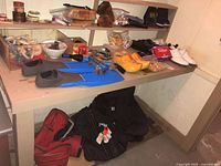 Overview of bench with fins, clogs, shoes, tools, bags underneath