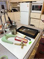 Overall lot on countertop showing juicer, tray, knife, keg tap, pail