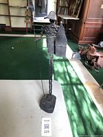 Tall metal wire figure sculpture with spear and shield on weighted base