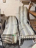 Two Regal vinyl strap chaise lounges with cushions side by side