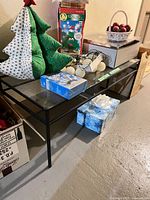 Full view of rectangular black metal frame table with glass top