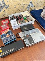 overview of lot showing batteries, cassette tapes, recorders and Sony Watchman
