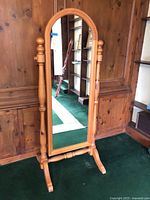 Full view of pine standing mirror on green carpet