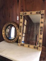Round convex mirror and rectangular mirror on table
