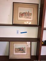 Both framed prints on shelving showing overall appearance