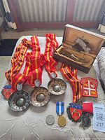Group shot of tastevins, medals, box, patch and coin