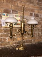 Full view of brass double-arm lamp showing both glass shades and chimneys