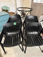 Four matching black slatted Vondom Spritz chairs grouped together