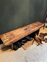 Full view of bench against wall with shoes underneath