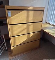 Front view of light oak 4-drawer filing cabinet