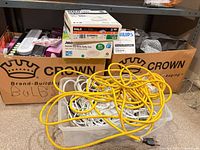 Overall lot showing boxes of bulbs, extension cord, tote of cords