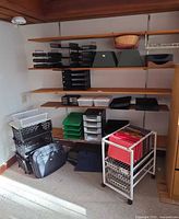 wide view of shelving with trays, racks, crates, cart and bag