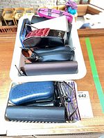 Two trays filled with multiple eyeglass cases and several prescription glasses